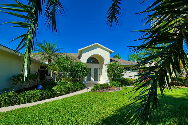 Schönes Haus mit Palmen und Garten.