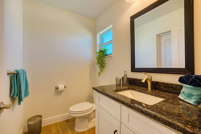 Gemütliches Badezimmer mit lila Waschbecken und stilvollem Holzschrank.