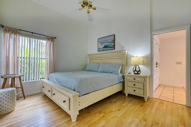 Gemütliches Schlafzimmer mit Holzmöbeln und blauem Bett, gemütliche Beleuchtung.