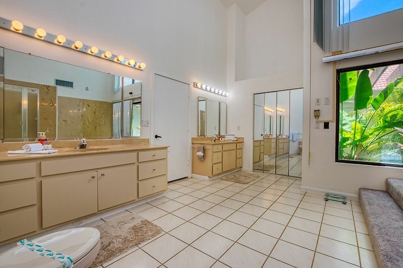 Moderne Badezimmerausstattung mit Spiegel, Waschbecken und Schrank.