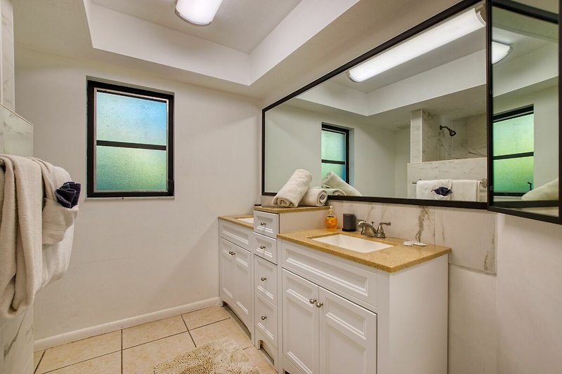 Ein stilvolles Badezimmer mit elegantem Waschtisch und modernem Spiegel.