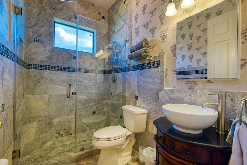 Badezimmer mit lila Akzenten, Spiegel und Waschbecken.
