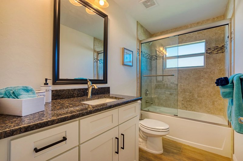 Stilvolles Badezimmer mit lila Waschbecken und Holzschrank.