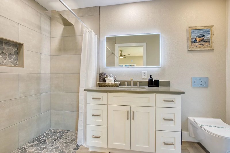 Gemütliches Badezimmer mit stilvoller Inneneinrichtung und Spiegel.