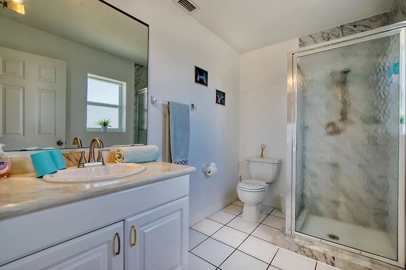 Modernes Badezimmer mit lila Waschbecken, Spiegel und stilvoller Beleuchtung.