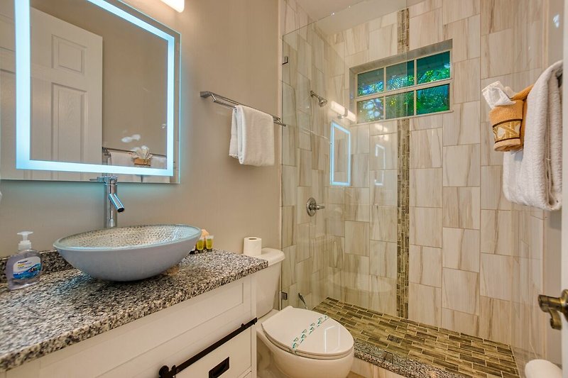 Schönes Badezimmer mit lila Akzenten und elegantem Design.