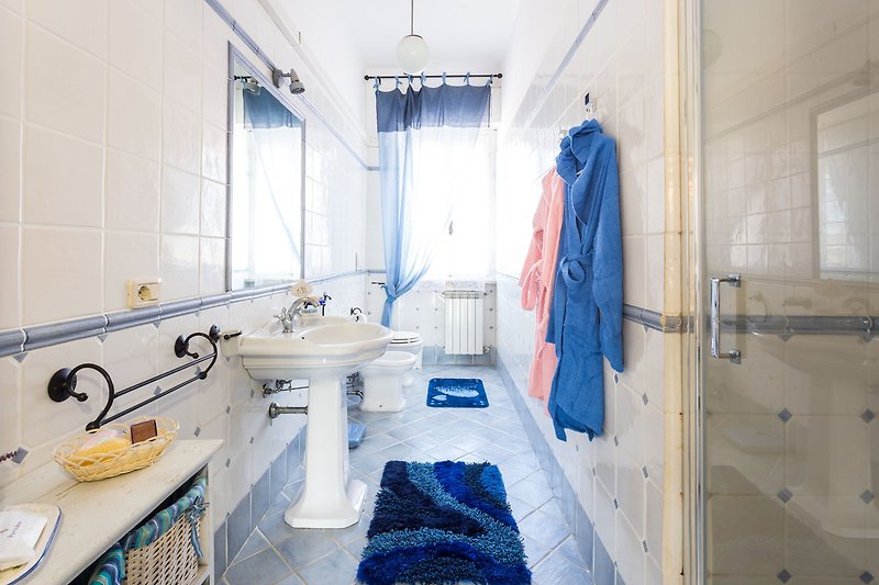 Un bagno moderno con specchio, lavandino e doccia idromassaggio