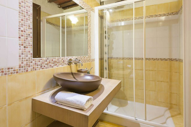 Un bagno moderno con lavandino, specchio e doccia idromassaggio