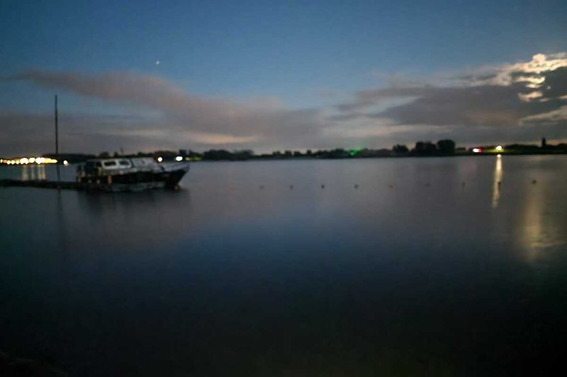 Schöne Abendstimmung am See mit Booten und Sonnenuntergang.