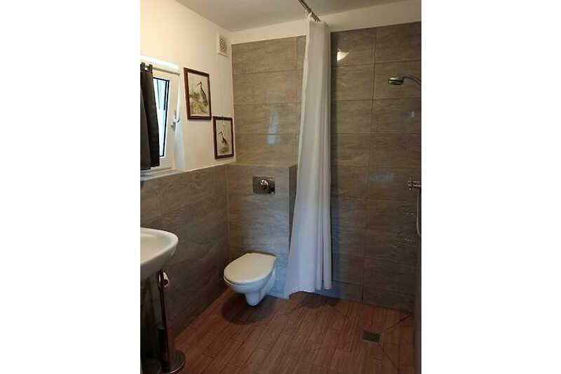 Schönes Badezimmer mit Holzboden und Spiegel.