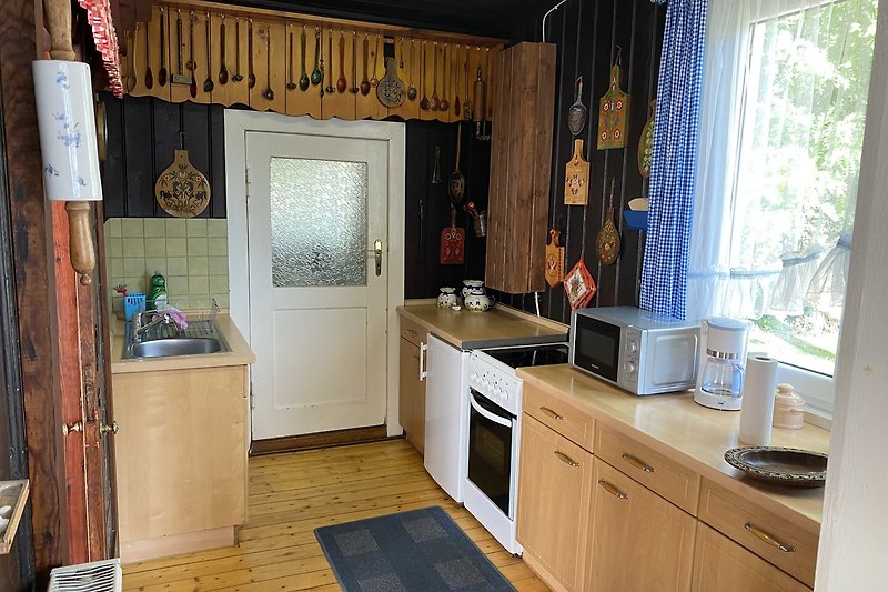 Moderne Küche mit Holzmöbeln, Fenster und Spüle.