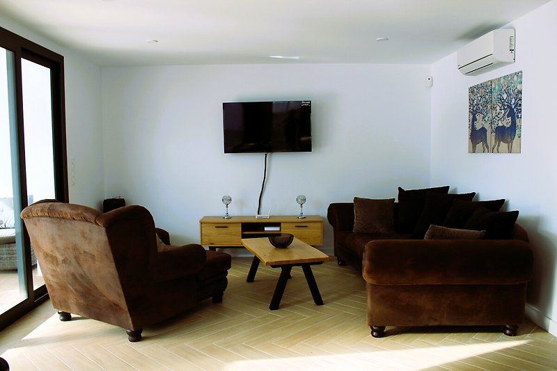 Gemütlicher Wohnbereich mit Flachbild-TV und Bluetooth-Box