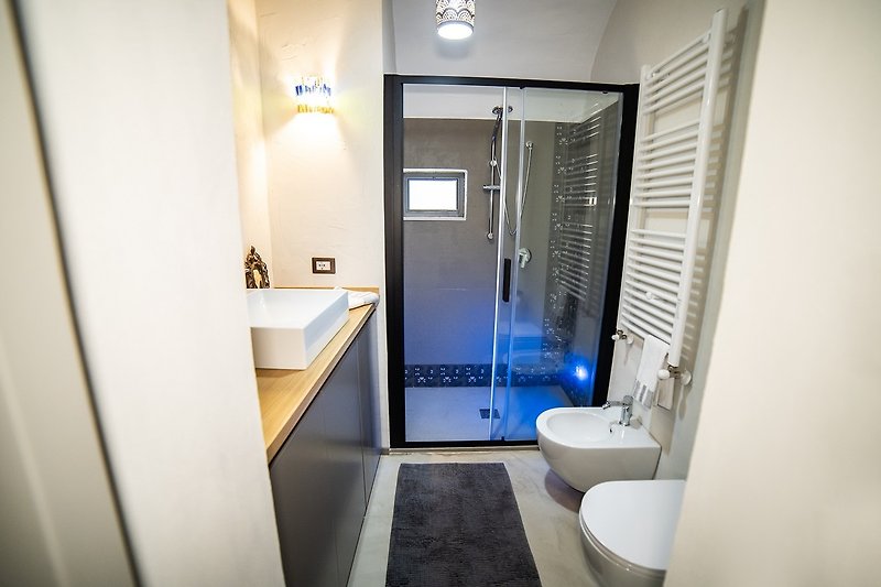 Un bagno viola con lavandino, specchio e rubinetto.