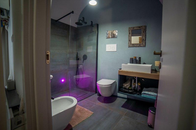 Un bagno viola con piastrelle di ceramica, lavandino e doccia.