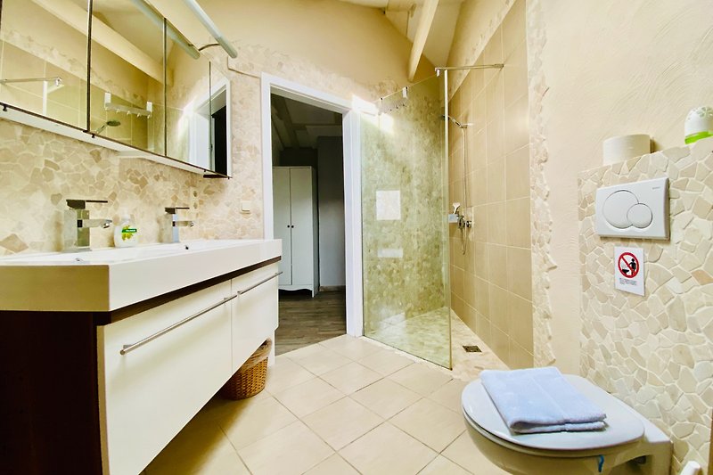 Ein modernes Badezimmer mit Spiegel, Waschbecken und Armaturen.