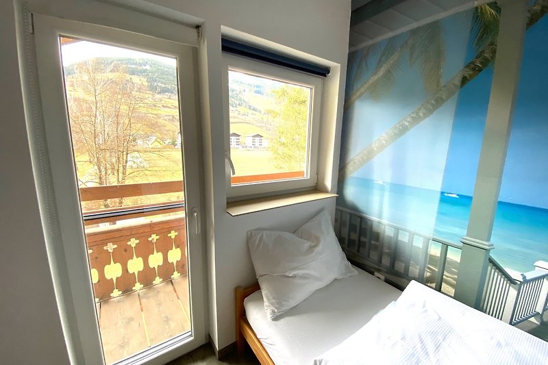 Ein komfortables Schlafzimmer mit Holzbett und Fensterdekoration.