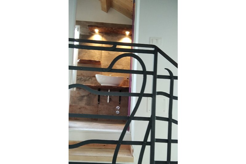Un particolare dell'interno: scaletta in legno con balaustra originale liberty in ferro battuto.