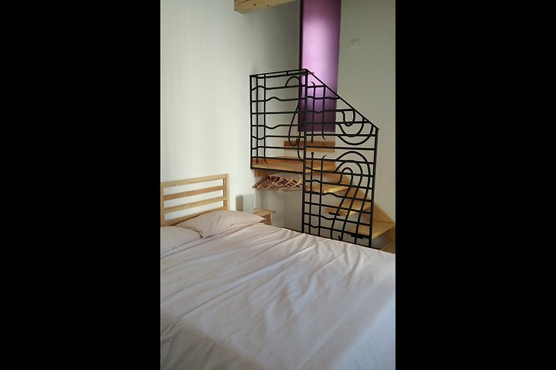 Una bella camera da letto confortevole che affaccia sul giardino,  con soffitto e arredamenti in legno massello e bagno.