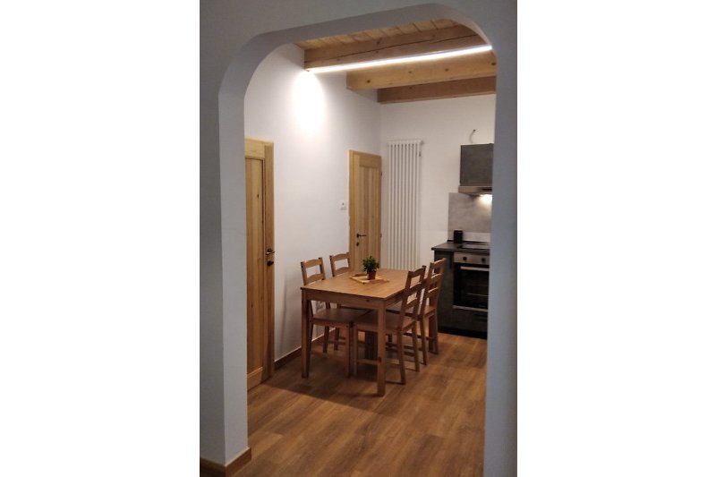 Una bella e accogliente cucina moderna con soffitto e mobili in legno e una luce soffusa.