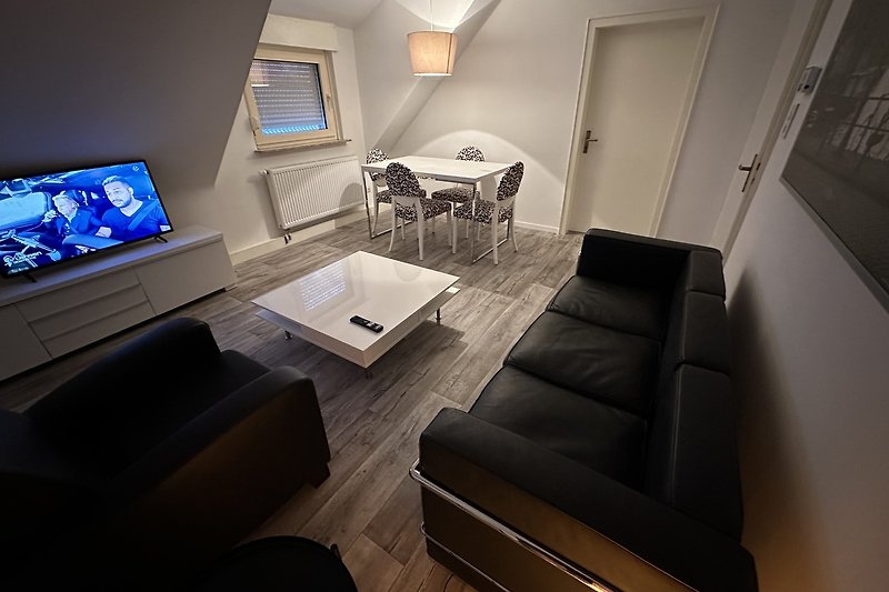 Stilvolles Wohnzimmer mit elegantem Mobiliar und modernem Flachbildfernseher.