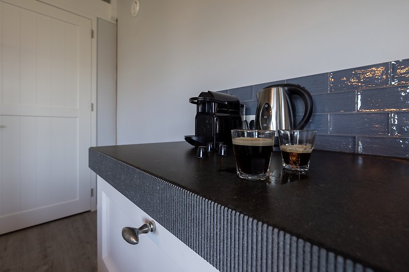 Prachtige keuken met houten kasten, aanrecht en Nespresso koffie.
