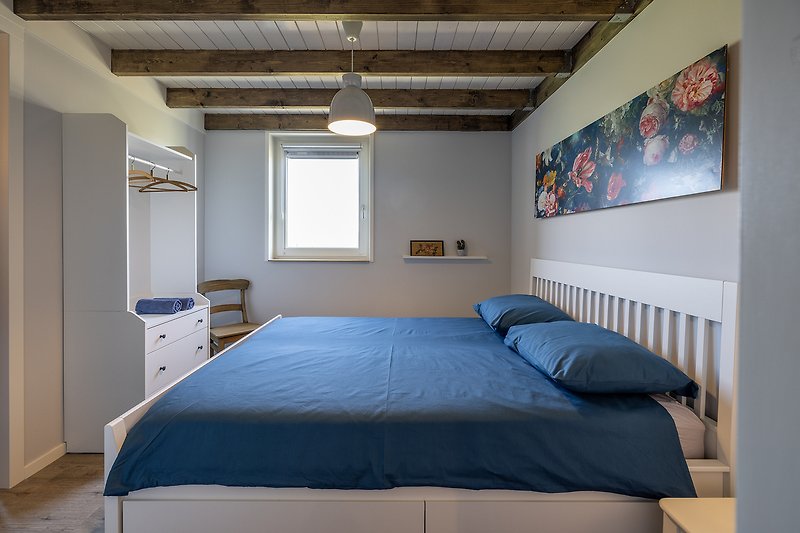 Comfortabele slaapkamer met houten meubels en beddengoed.