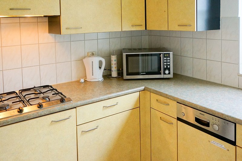 Separate Küche mit Gasherd, Kühlschrank und Geschirrspülmaschine