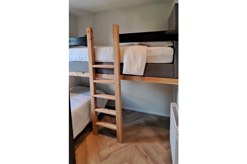 Comfortabele slaapkamer met twee eenpersoons boxsprings, waarvan 1 op hoogte.