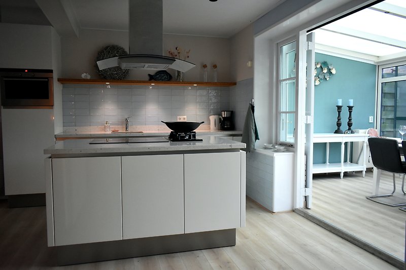 Moderne Küche mit Holzboden, Arbeitsplatte und Küchengeräten.