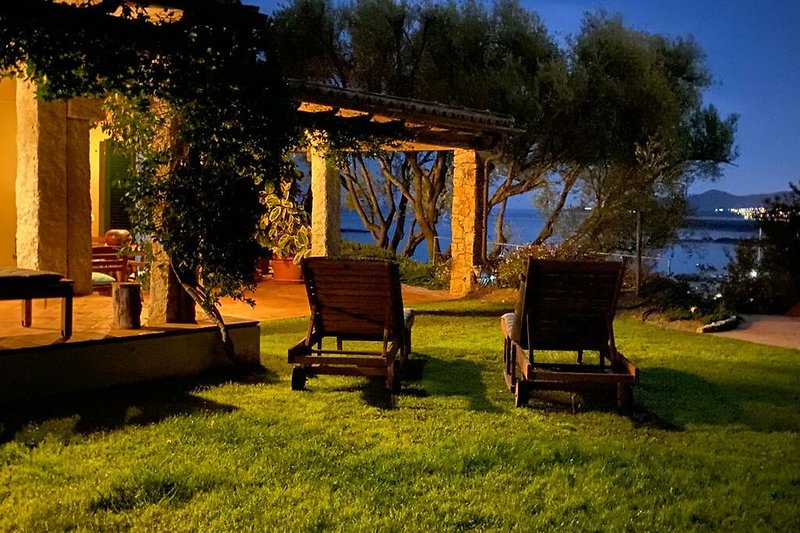 A picturesque outdoor retreat with lush greenery, wooden furniture, and a charming pergola.