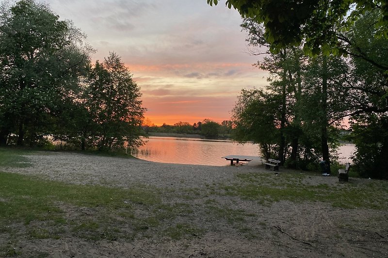 Schöne Landschaft mit See, Wiese und Sonnenuntergang. Perfekt für Naturliebhaber.