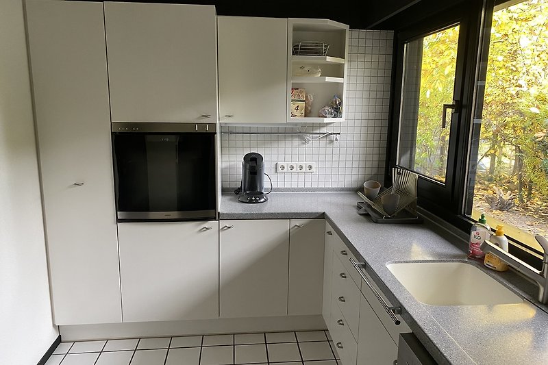 Moderne Küche mit stilvoller Einrichtung und großem Fenster.
