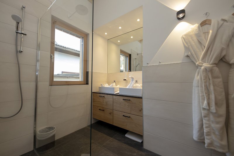 Gemütliches Badezimmer mit Spiegel, Schränken und Waschbecken.
