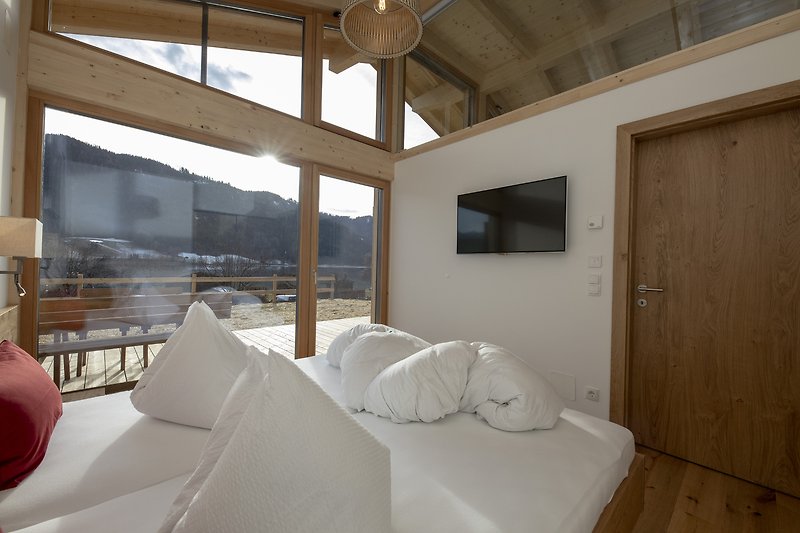 Gemütliches Wohnzimmer mit Holzmöbeln und großem Fenster.