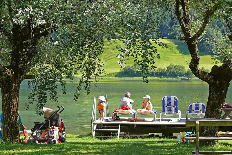 Eine entspannte Naturidylle mit Menschen, die draußen sitzen und die grüne Landschaft genießen.