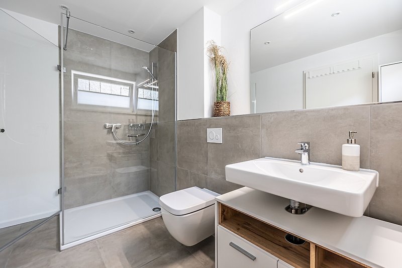 Spiegel, Wasserhahn, Waschbecken und Badezimmermöbel in modernem Design.