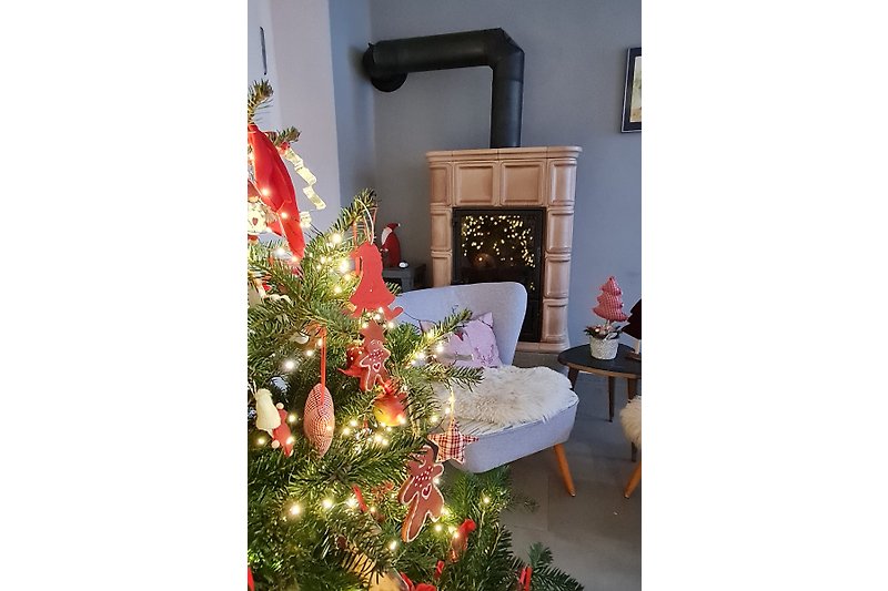 Liebevoll dekoriertes Wohnzimmer mit Holzofen in der Weihnachtszeit
