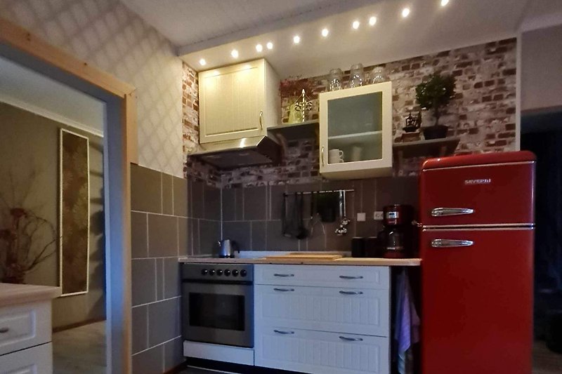Ein stilvolles Kücheninterieur mit schönen Schränken und Holzboden.