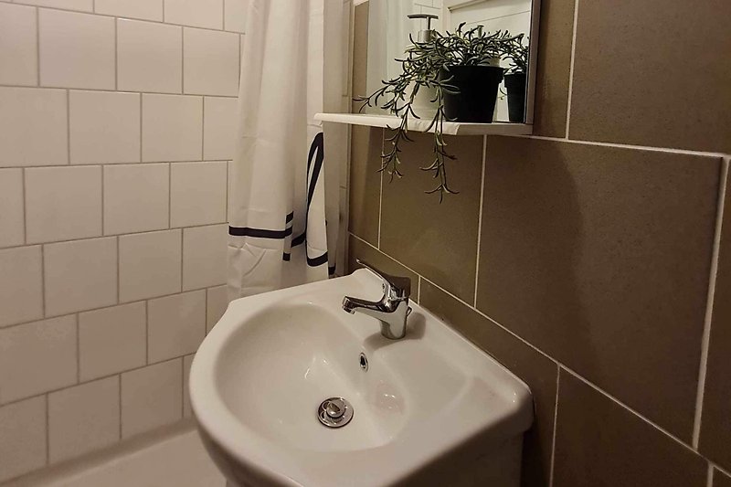 Ein stilvolles Badezimmer mit einer lila Spüle und einem schönen Spiegel.