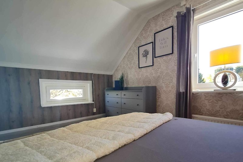 Ein stilvolles Schlafzimmer mit gemütlichem Bett und modernen Möbeln.