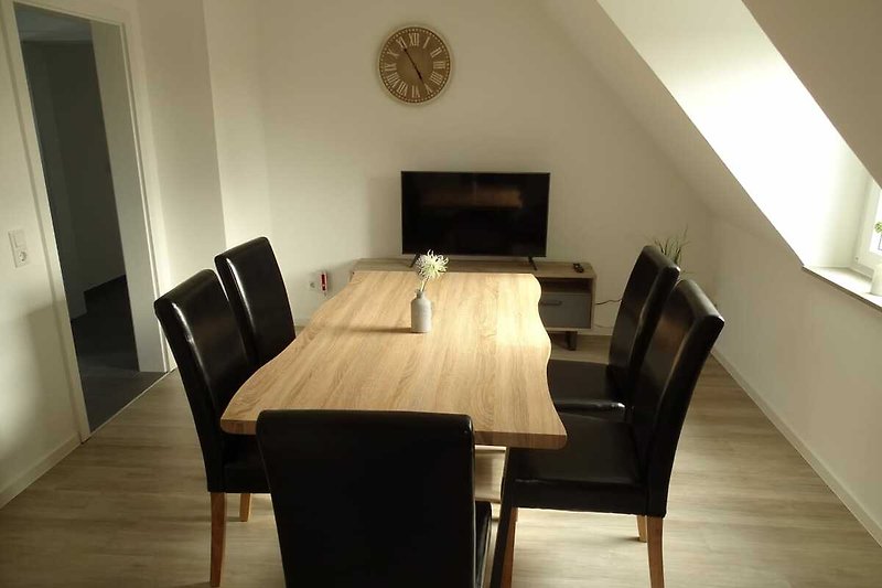 Gemütliches Wohnzimmer mit stilvollen Möbeln und Holzboden.