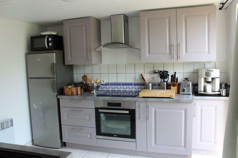 Schöne Küche mit modernen Geräten und Holzboden.