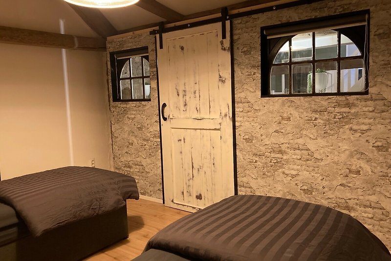 Een comfortabele slaapkamer met warme verlichting en een houten bedframe.