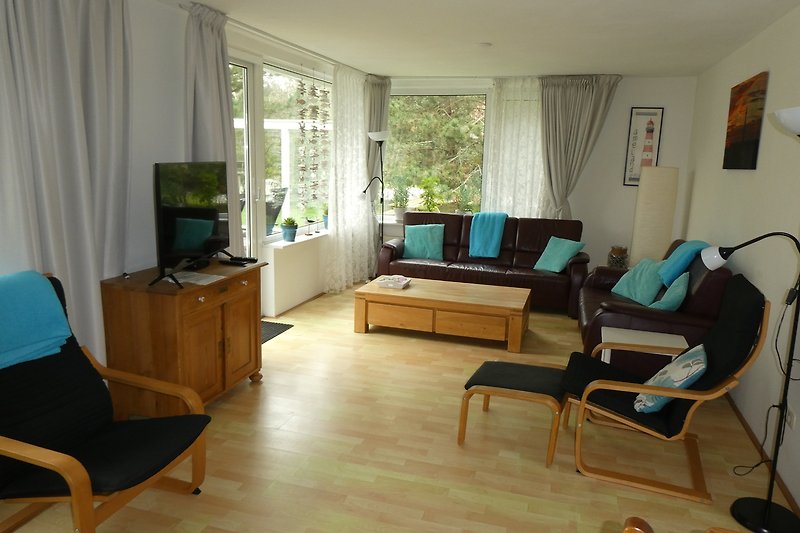 Gemütliches Wohnzimmer mit grüner Couch und Holzmöbeln.