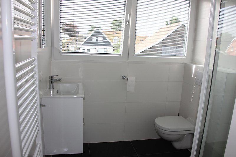 Stilvolles Badezimmer mit Fenster, Toilette und elegantem Design.