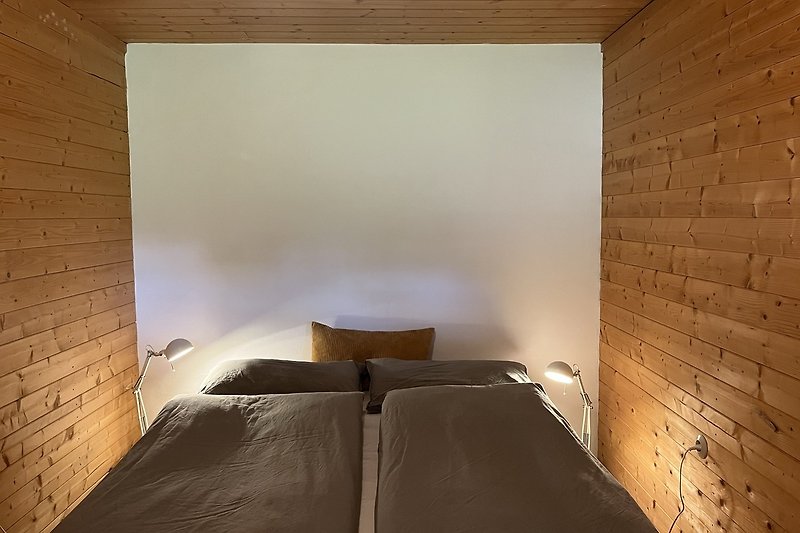 Komfortables Schlafzimmer mit Holzboden und stilvoller Einrichtung.