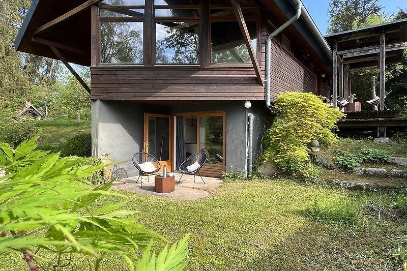 Ein charmantes Holzhaus mit grünem Garten und weitem Himmelblick.