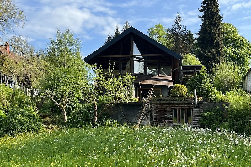 Ein idyllisches Häuschen mit grünem Garten und weitem Himmelblick.