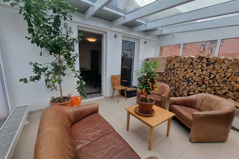 Gemütlicher Wintergarten mit stilvoller Einrichtung und bequemer Couch. (beheizbar)