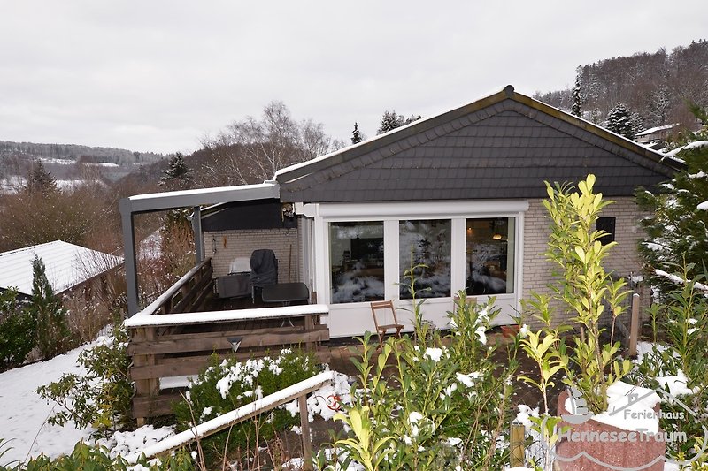 Schönes Haus mit winterlicher Landschaft und verschneitem Dach.